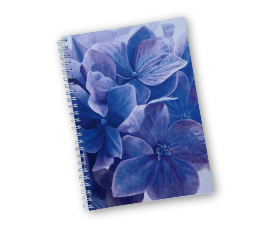 A notebook with a hydrangea floral pattern cover in shades of blue and a softcover binding.